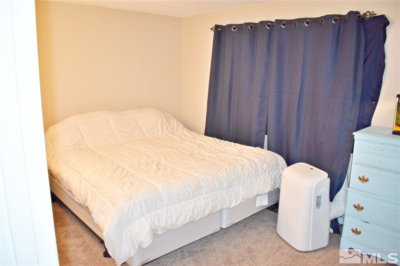 9185 Fremont Way Reno, NV 89506 - Photo 7 of 10 a bed sitting in a bedroom next to a wooden cabinet