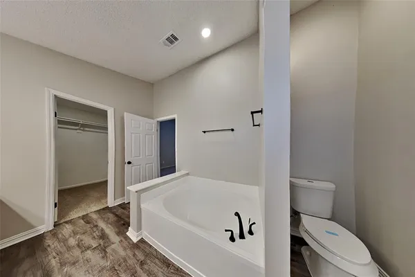 a bathroom with a tub and toilet