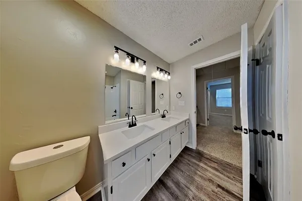 a bathroom with a double vanity sink toilet and shower