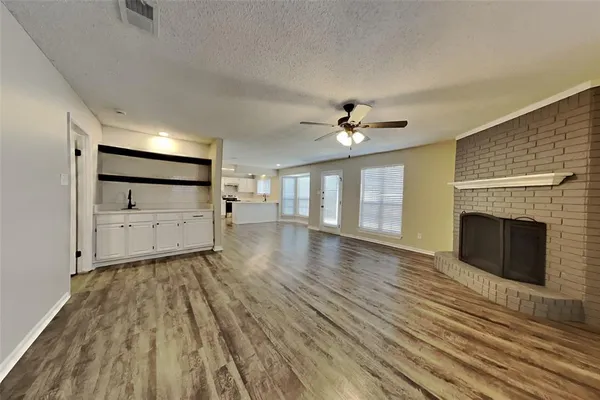 a view of a livingroom with wooden floor and fireplace