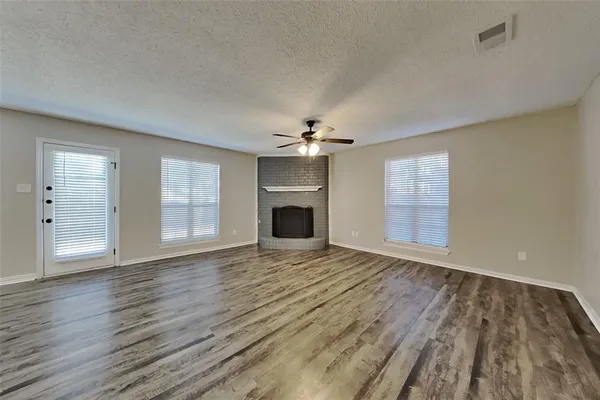 a view of an empty room with a fireplace and a window