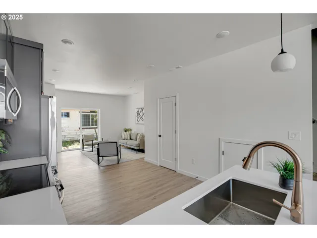 a kitchen with granite countertop a refrigerator stove top oven and sink