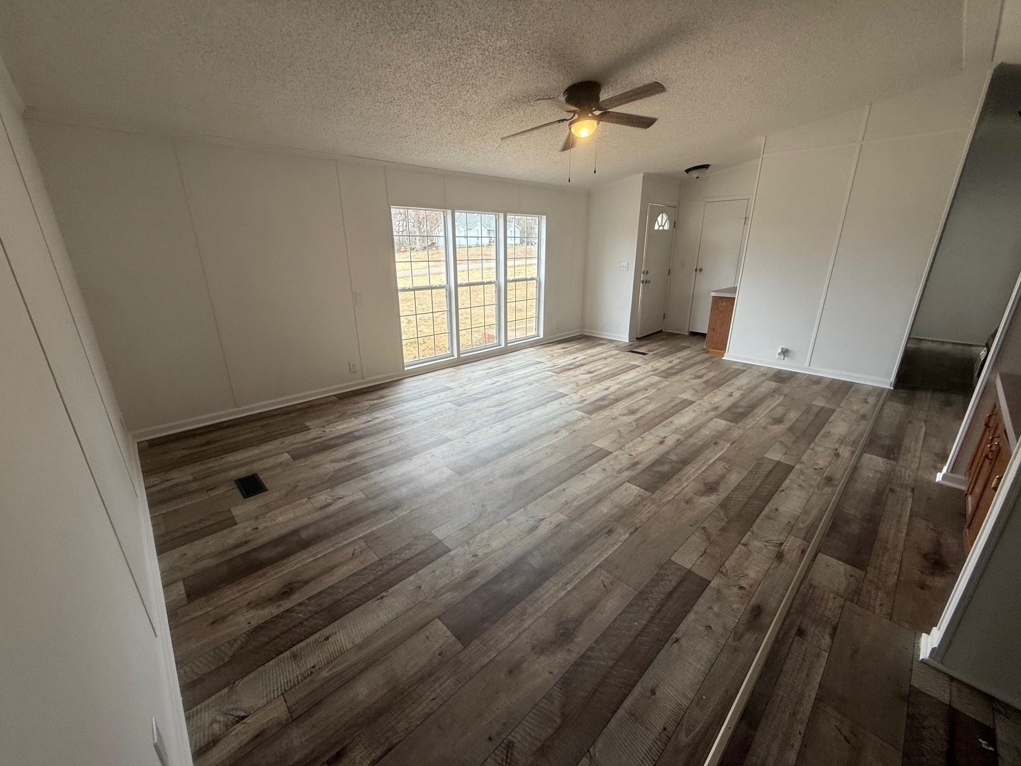 1688 Hardin Graveyard Road Adamsville, TN 38310 - Photo 7 of 40 an empty room with wooden floor and windows