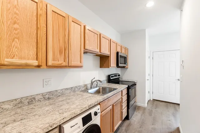 a kitchen with stainless steel appliances granite countertop a sink stove and cabinets