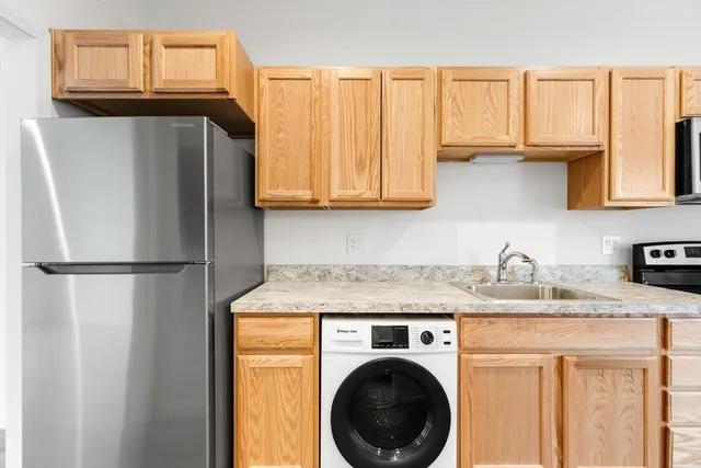 a kitchen with a refrigerator sink and cabinets