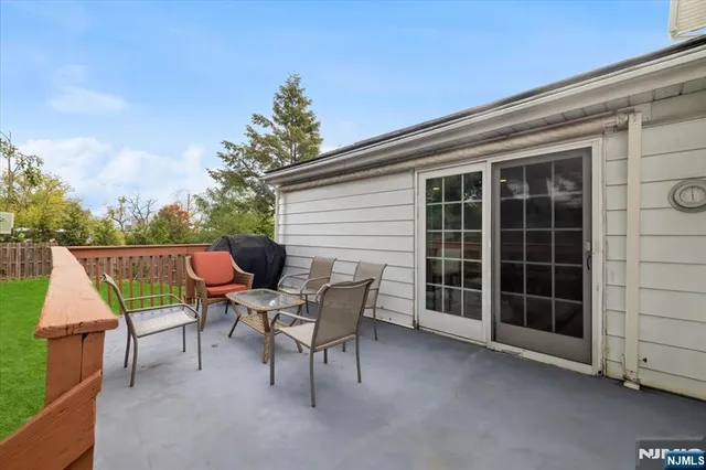 a roof deck with table and chairs and potted plants