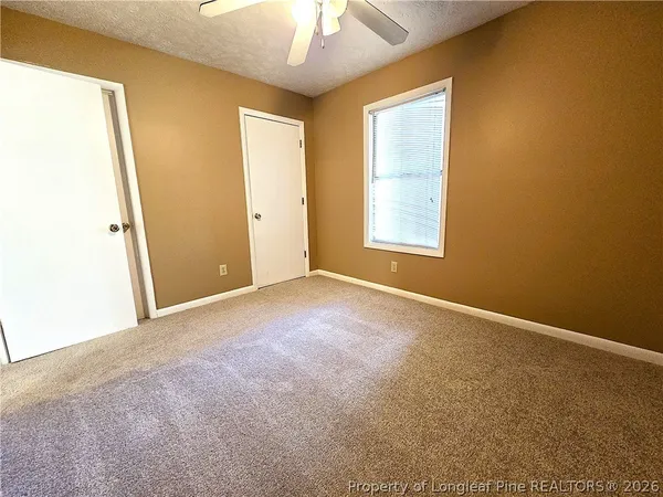 an empty room with a window and a ceiling fan