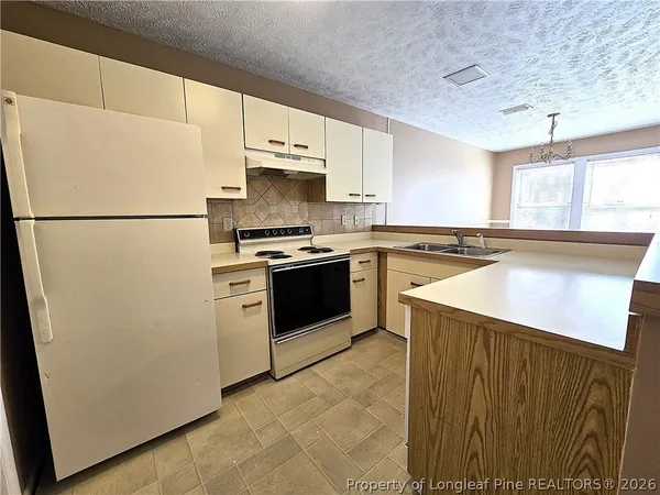 a kitchen with a stove a refrigerator and a sink