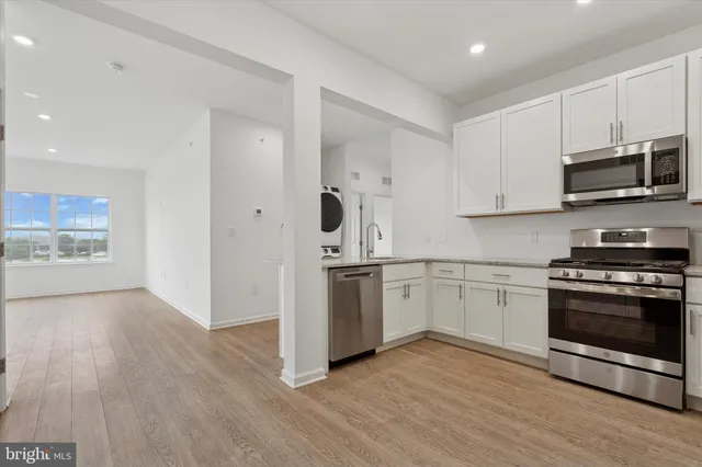 a kitchen with cabinets stainless steel appliances and a sink