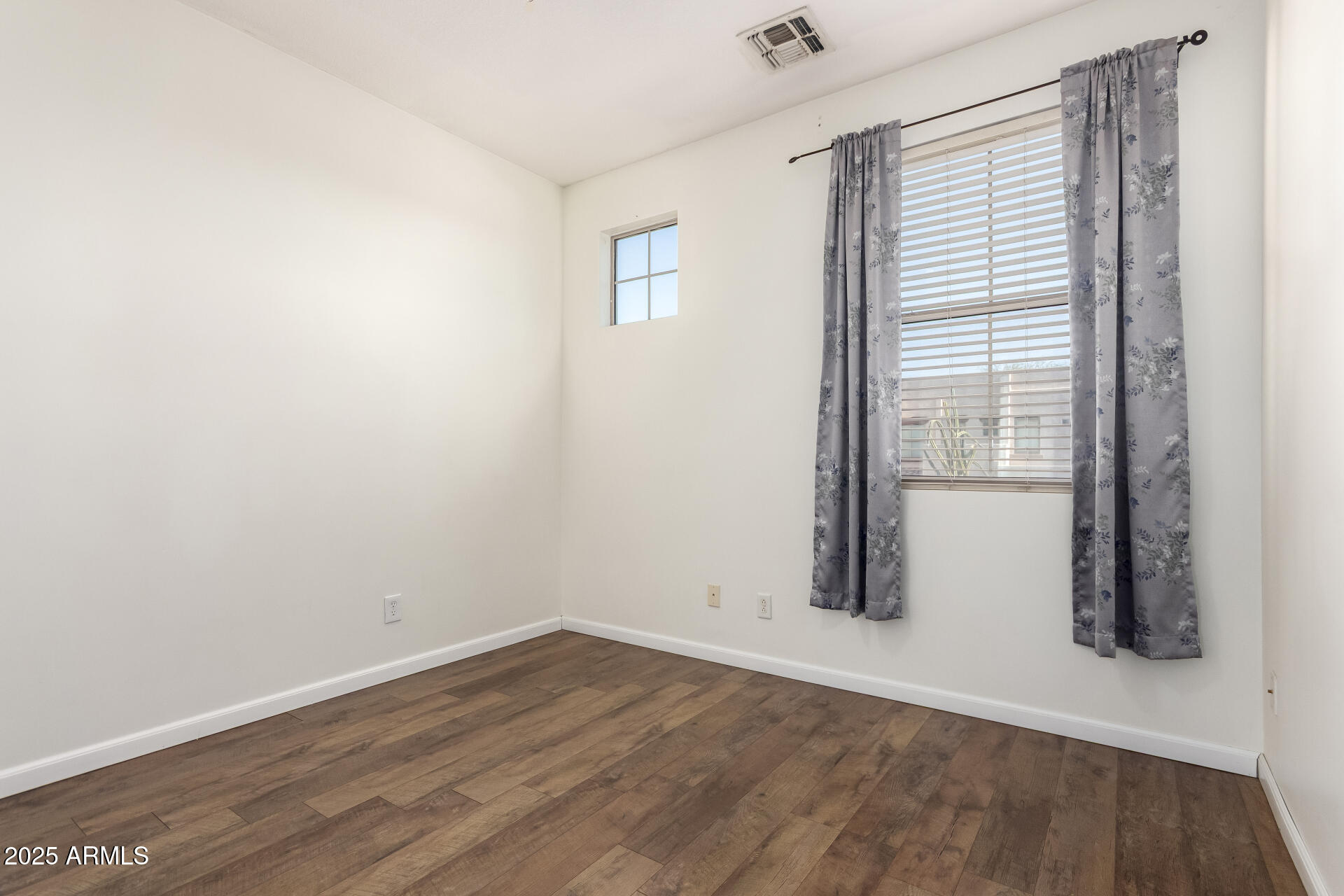 1886 East Don Carlos, Unit 147 Tempe, AZ 85281 - Photo 12 of 22 an empty room with wooden floor and windows