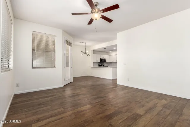 a view of a kitchen with wooden floor and a ceiling fan