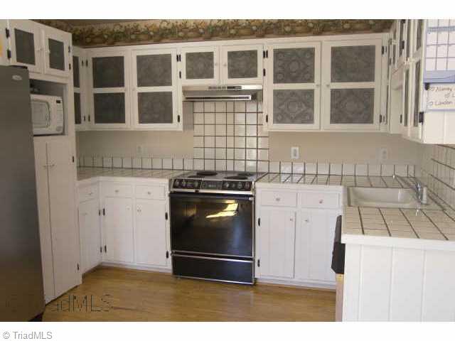 5126 Dock Davis Road Clemmons, NC 27012 - Photo 4 of 9 Other. Kitchen with tile counters and punched tin cabinet inserts
