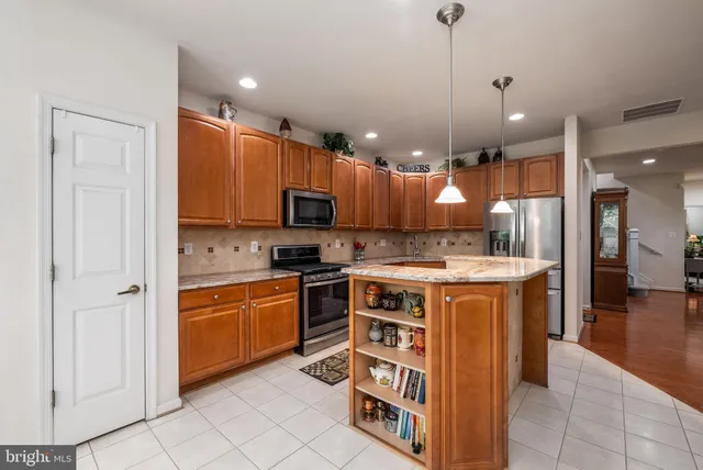 a kitchen with stainless steel appliances granite countertop a stove sink microwave and refrigerator