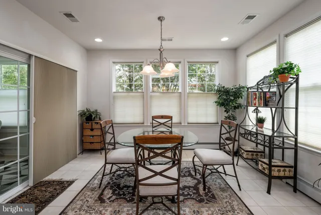 a kitchen with stainless steel appliances kitchen island granite countertop a table chairs and a refrigerator