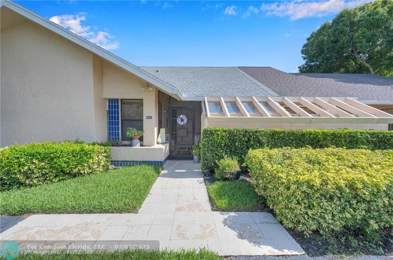 10999 Water Oak Manor Boca Raton, FL 33498 - Photo 1 of 49 a front view of a house with a yard