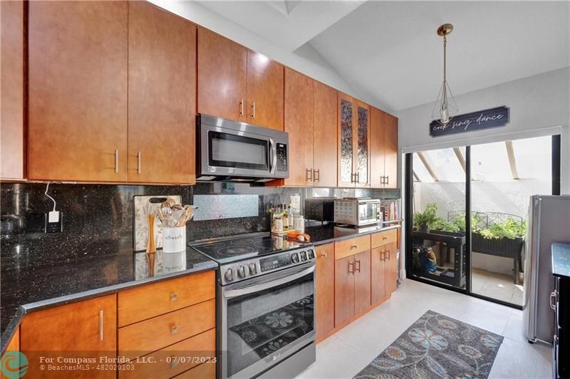 10999 Water Oak Manor Boca Raton, FL 33498 - Photo 11 of 49 a kitchen with stainless steel appliances granite countertop a stove a sink and a microwave