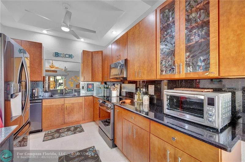 10999 Water Oak Manor Boca Raton, FL 33498 - Photo 12 of 49 a kitchen with stainless steel appliances granite countertop a stove a sink and a refrigerator