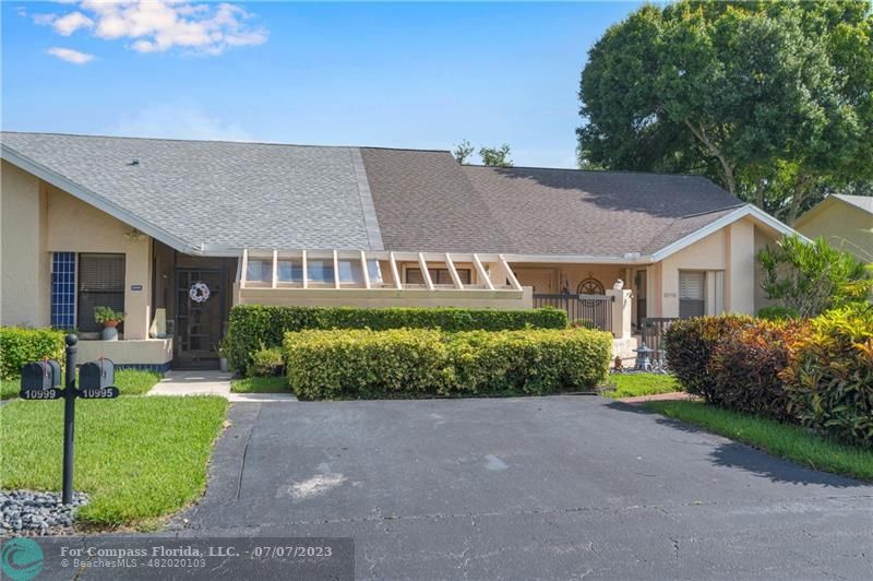 10999 Water Oak Manor Boca Raton, FL 33498 - Photo 40 of 49 a front view of a house with a yard and outdoor seating