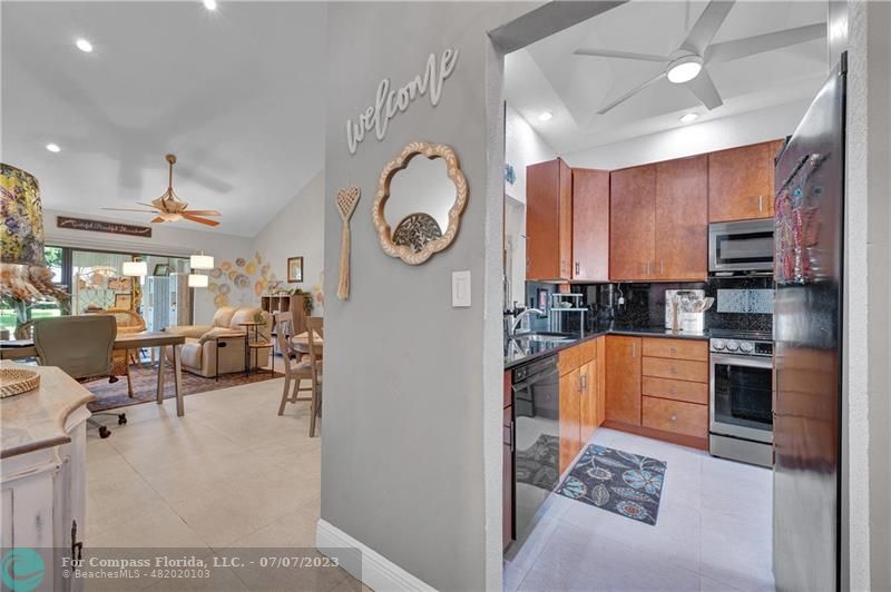 10999 Water Oak Manor Boca Raton, FL 33498 - Photo 7 of 49 a kitchen with stainless steel appliances granite countertop a refrigerator a stove top oven a sink and dishwasher