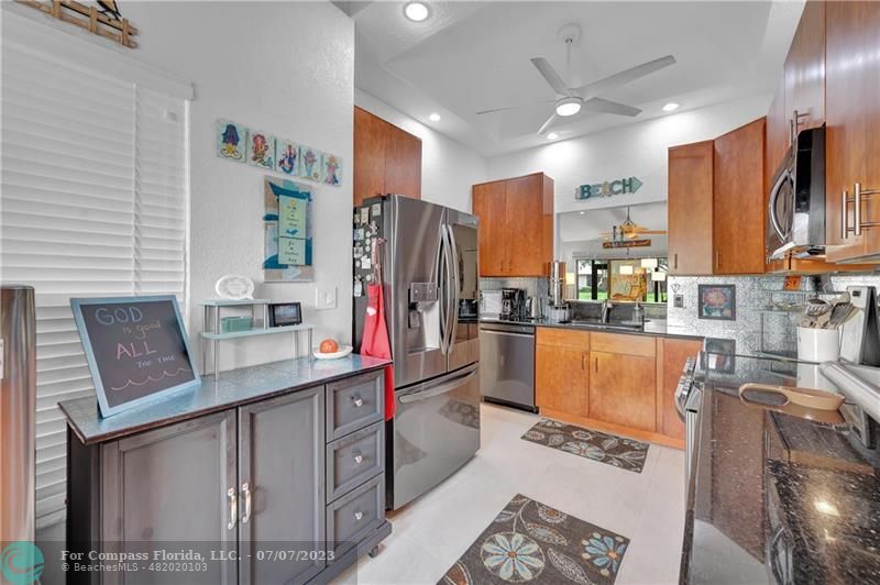 10999 Water Oak Manor Boca Raton, FL 33498 - Photo 10 of 49 a kitchen with stainless steel appliances kitchen island granite countertop a refrigerator a stove and a sink with wooden floor