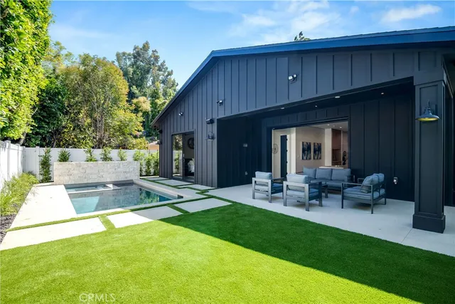 a view of swimming pool with lawn chairs and plants
