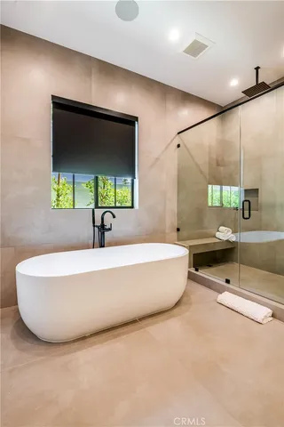a large white kitchen with a large window and stainless steel appliances