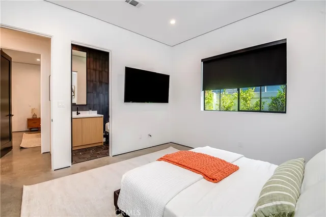 a bedroom with a bed and a flat screen tv