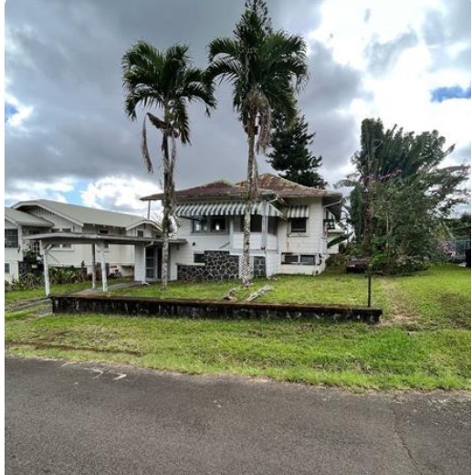 a view of a house with a big yard and palm trees