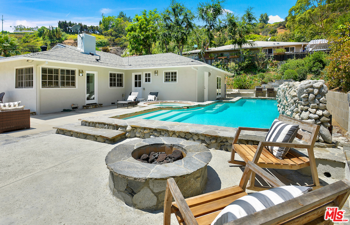 a view of a patio with table and chairs near a yard