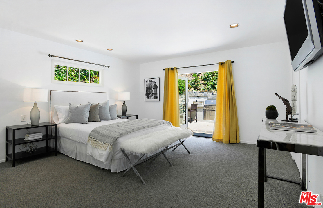 9573 Stuart Lane Beverly Hills, CA 90210 - Photo 13 of 24 a bedroom with a bed flat screen tv and window