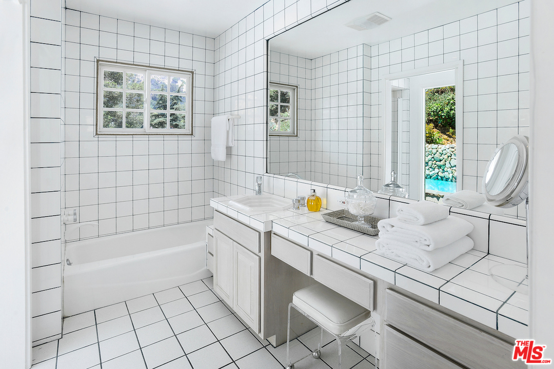9573 Stuart Lane Beverly Hills, CA 90210 - Photo 15 of 24 a bathroom with a sink a bathtub and next to a window