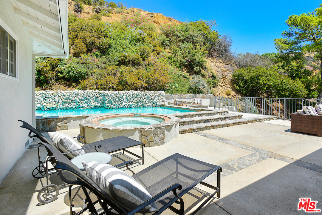 9573 Stuart Lane Beverly Hills, CA 90210 - Photo 17 of 24 a view of a swimming pool with lounge chairs