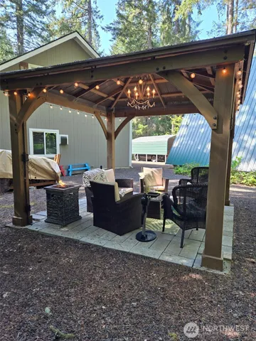 a view of a patio with table and chairs with a barbeque grill and plants