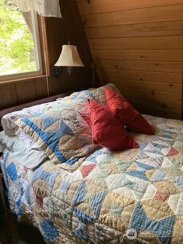 a bed sitting in a bedroom next to a window