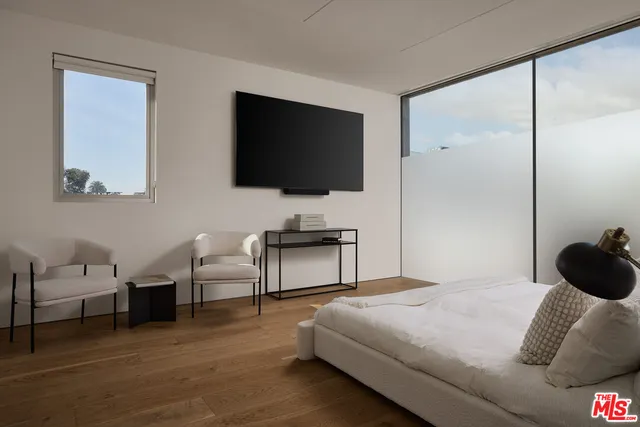 a bedroom with a bed and a flat screen tv
