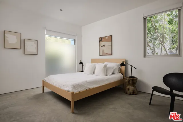 a bedroom with a bed lamp and a window