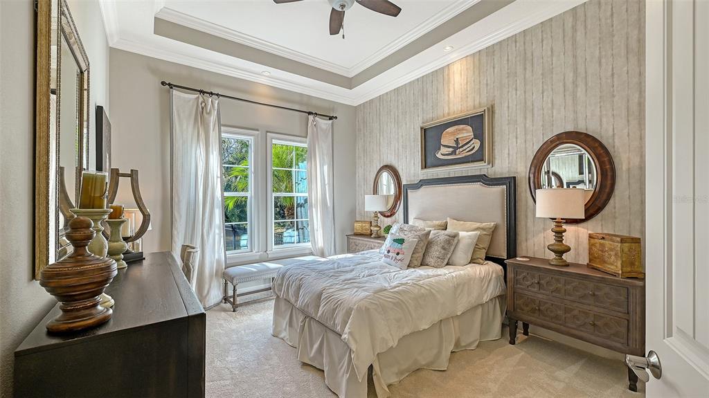 9489 Swaying Branch Road Sarasota, FL 34241 - Photo 16 of 37 a bedroom with a bed and a chandelier