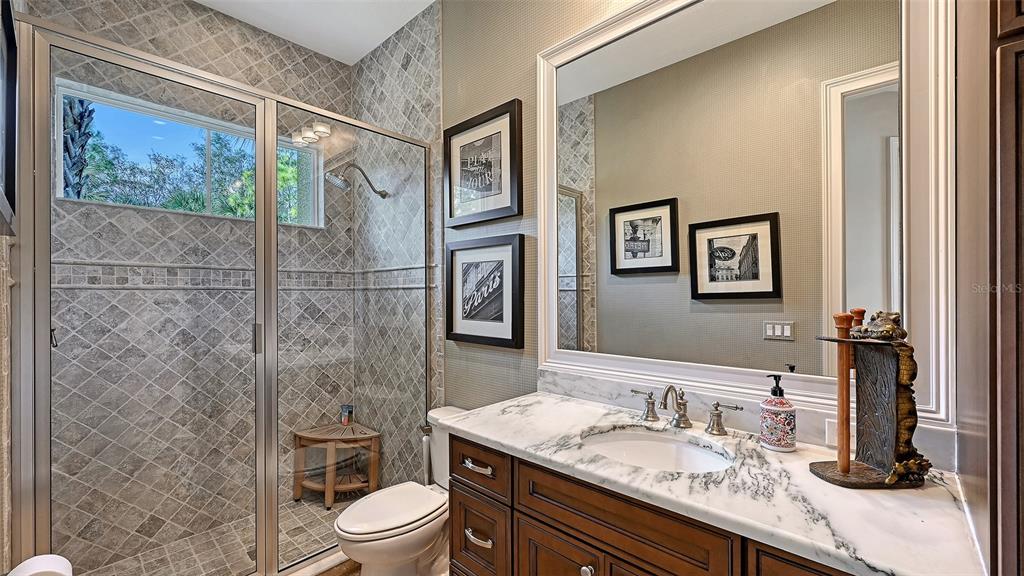 9489 Swaying Branch Road Sarasota, FL 34241 - Photo 17 of 37 a bathroom with a granite countertop sink toilet a mirror and shower