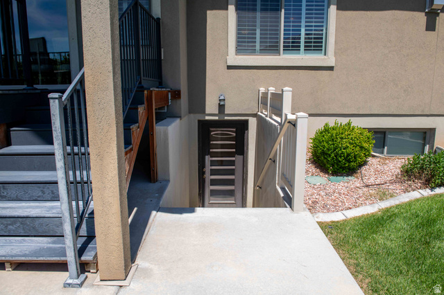 646 East 1400th Street North Mapleton, UT 84664 - Photo 74 of 78 Daylight basement entrance featuring a privacy fence, concrete walkway, and exterior lighting