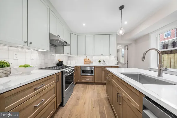 a kitchen with a sink stove top oven and cabinets