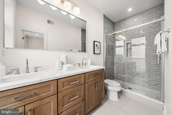 a bathroom with a granite countertop sink toilet and shower