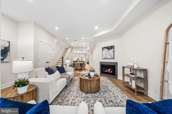 a living room with furniture a fireplace and a potted plant