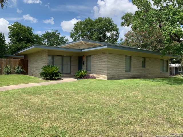 a front view of house with yard and trees