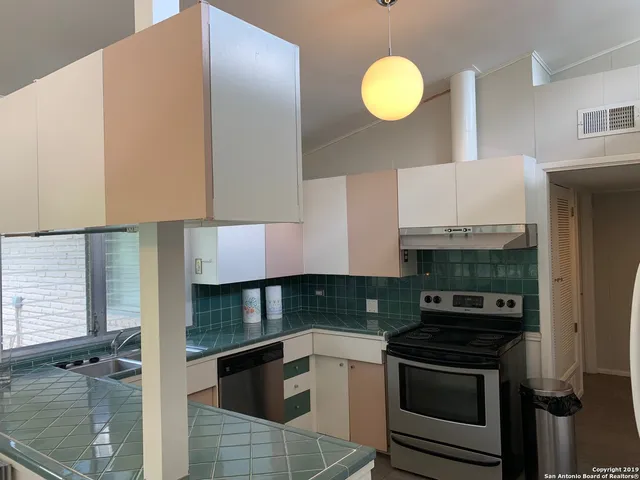 a kitchen with granite countertop a stove and a sink