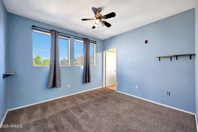 a view of a livingroom with a ceiling fan and window