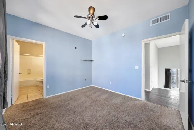 a view of a room with a ceiling fan and a bathroom