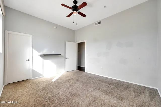 a view of a big room with a ceiling fan and window