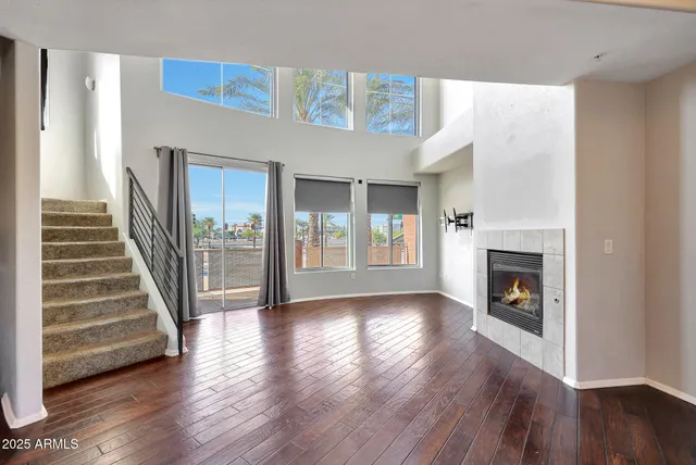 a view of a livingroom with wooden floor and a fireplace