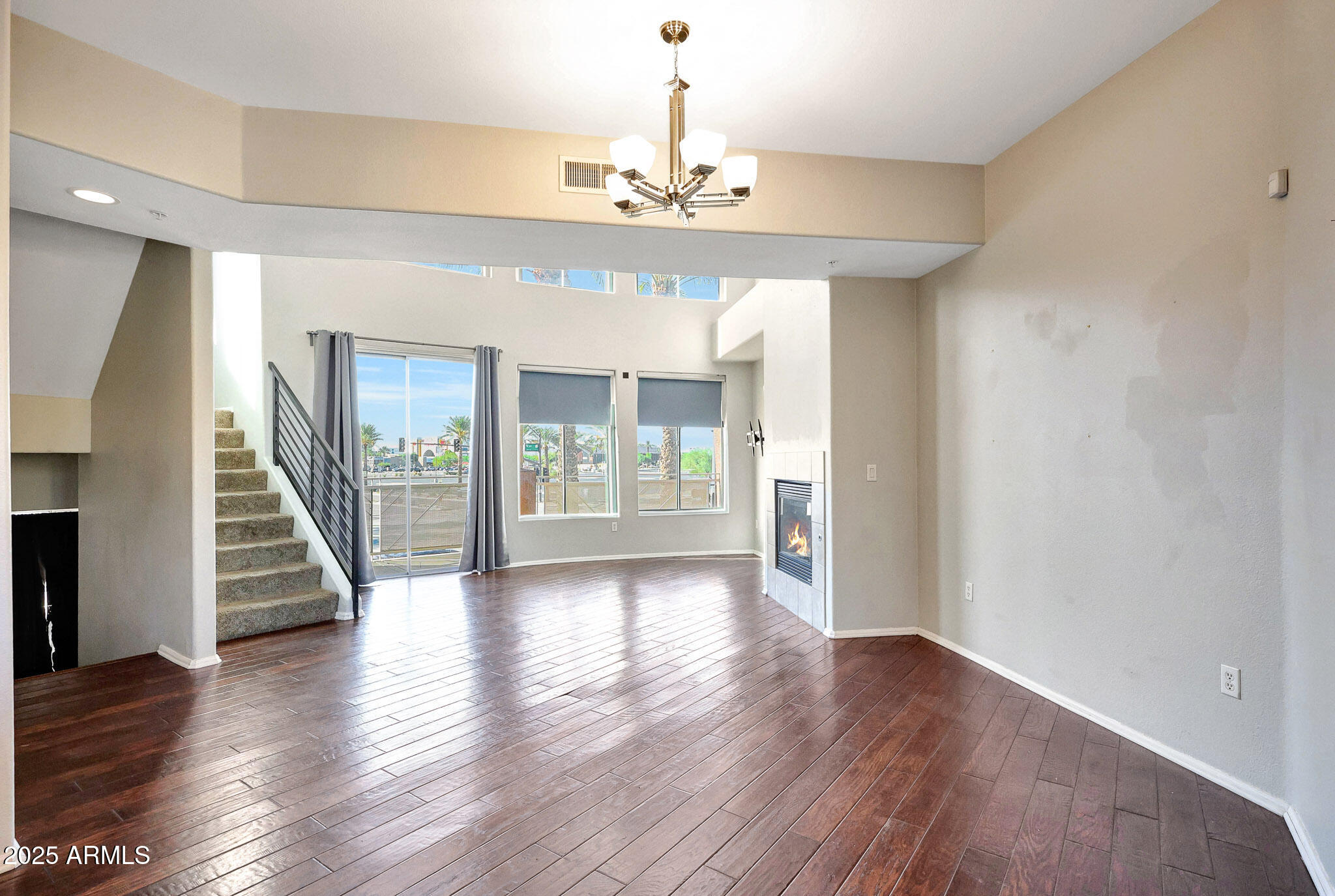 6605 North 93RD Avenue, Unit 1067 Glendale, AZ 85305 - Photo 6 of 47 an empty room with wooden floor chandelier and windows