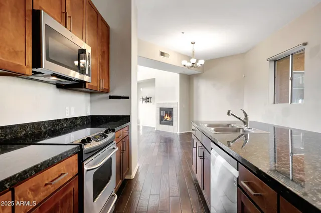 a kitchen with stainless steel appliances granite countertop a sink and stove top oven